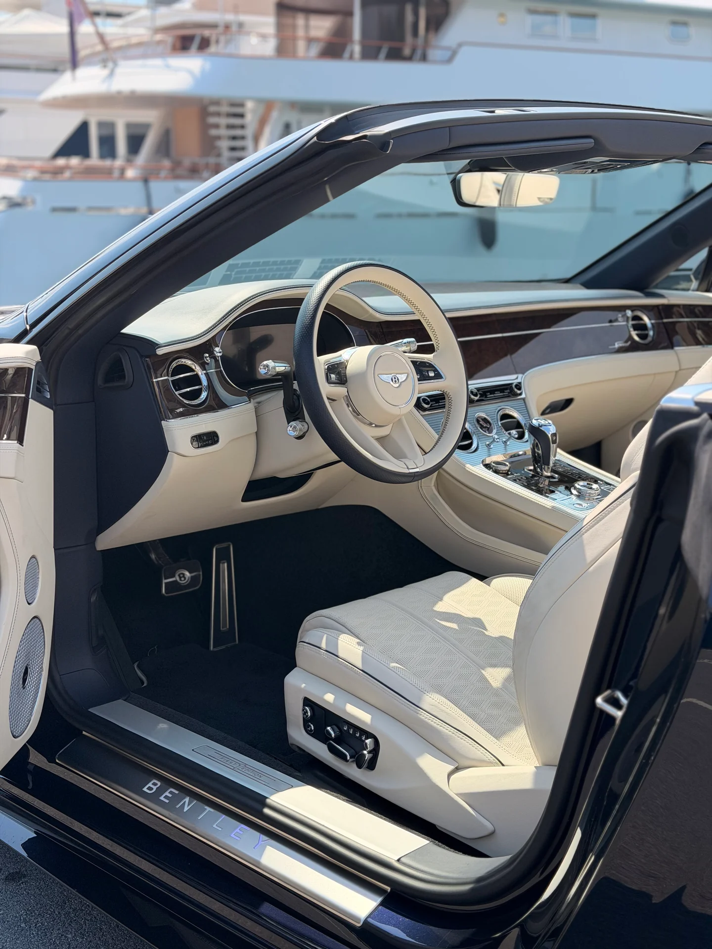 Light Bentley Continental GTC cabin showing the steering wheel, dashboard and front seat