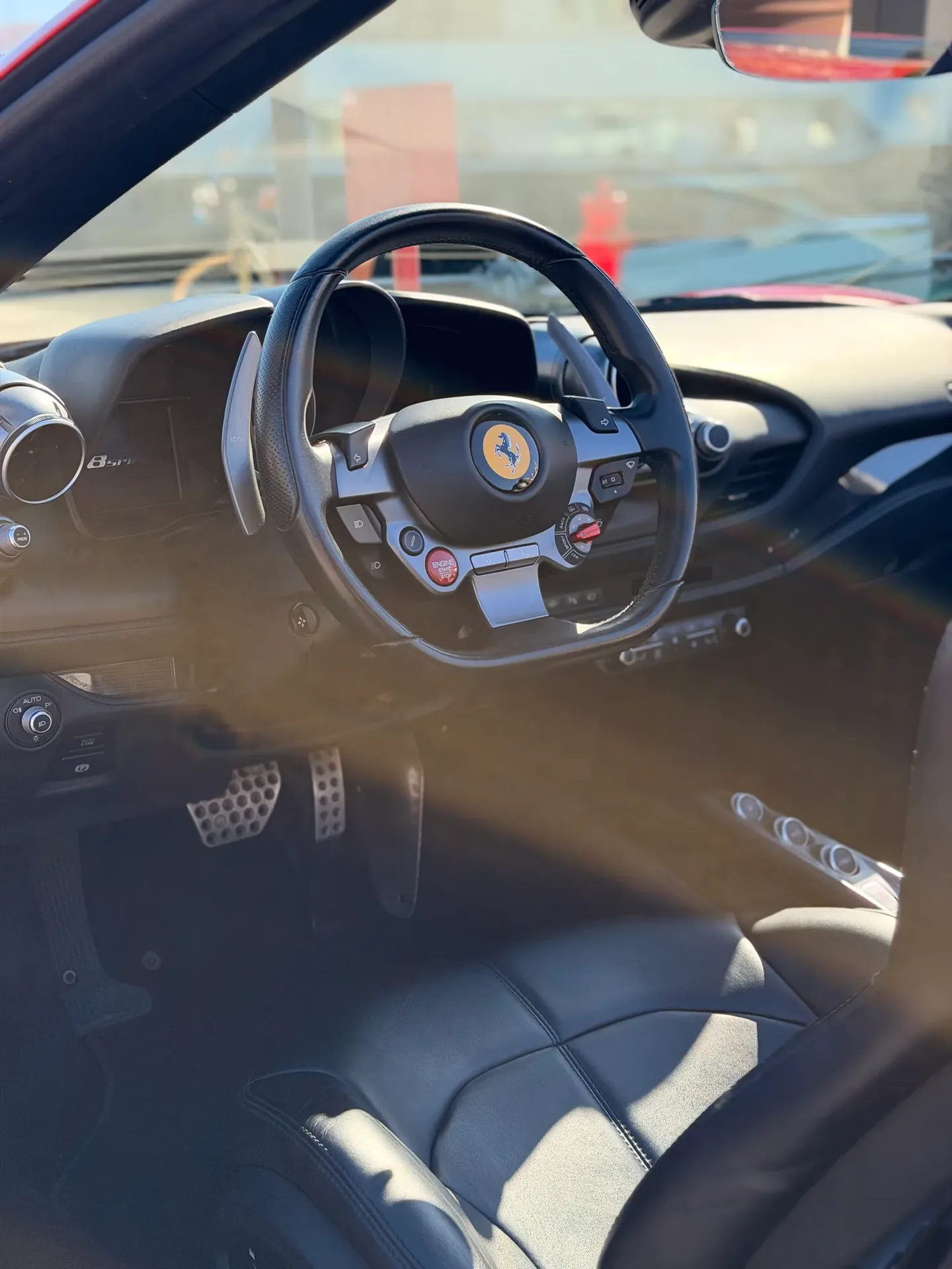 Ferrari F8 interior showing the steering wheel, dashboard and driver’s seat.