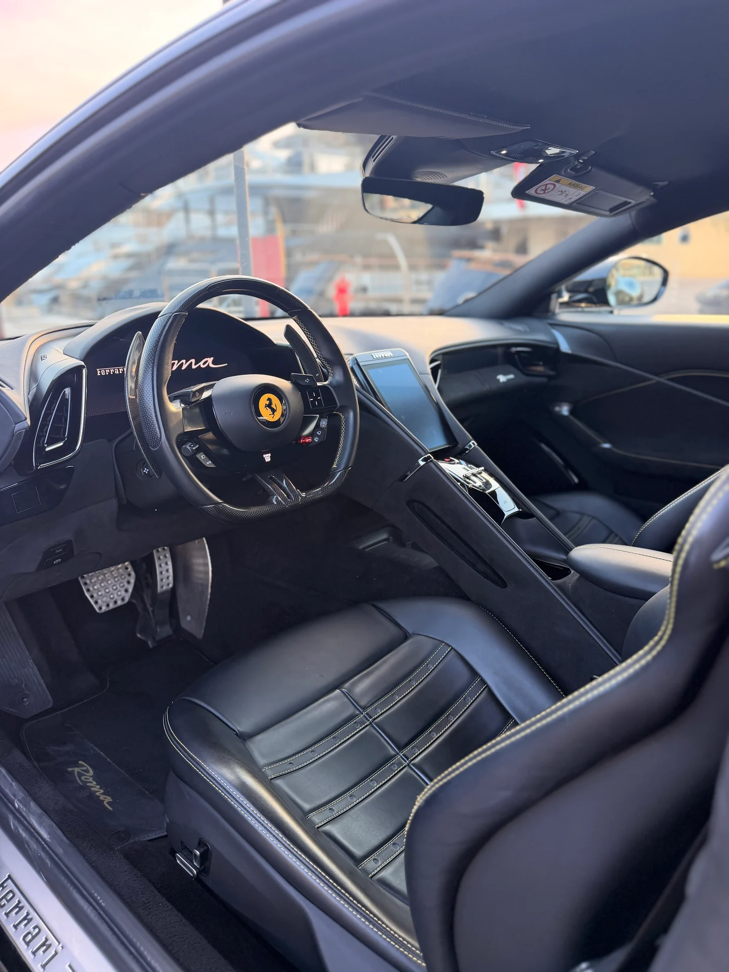 Ferrari Roma Coupé interior showing the dark driver’s seat, steering wheel and centre console