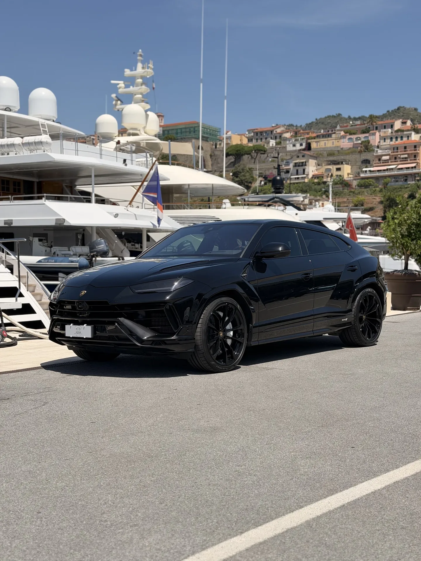Black Lamborghini Urus seen from the front three-quarter angle beside yachts